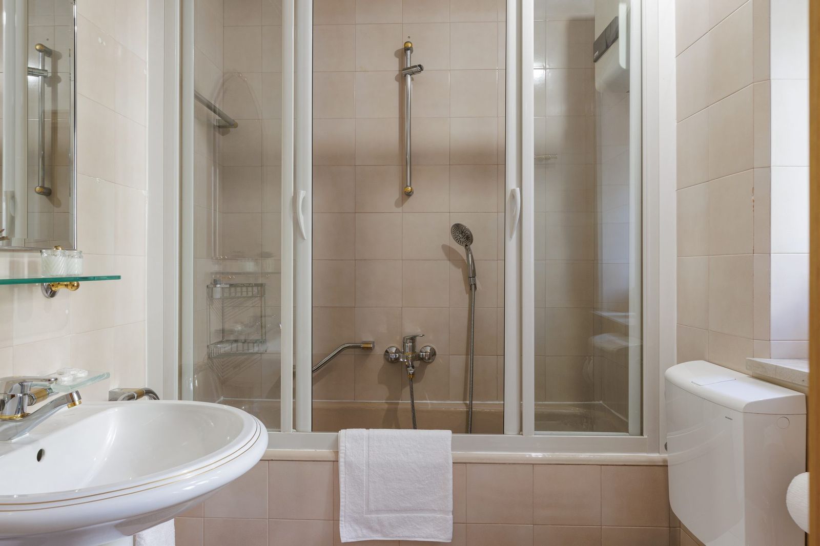 Bathroom, bathtub with sliding glass shower screen and pink tiles