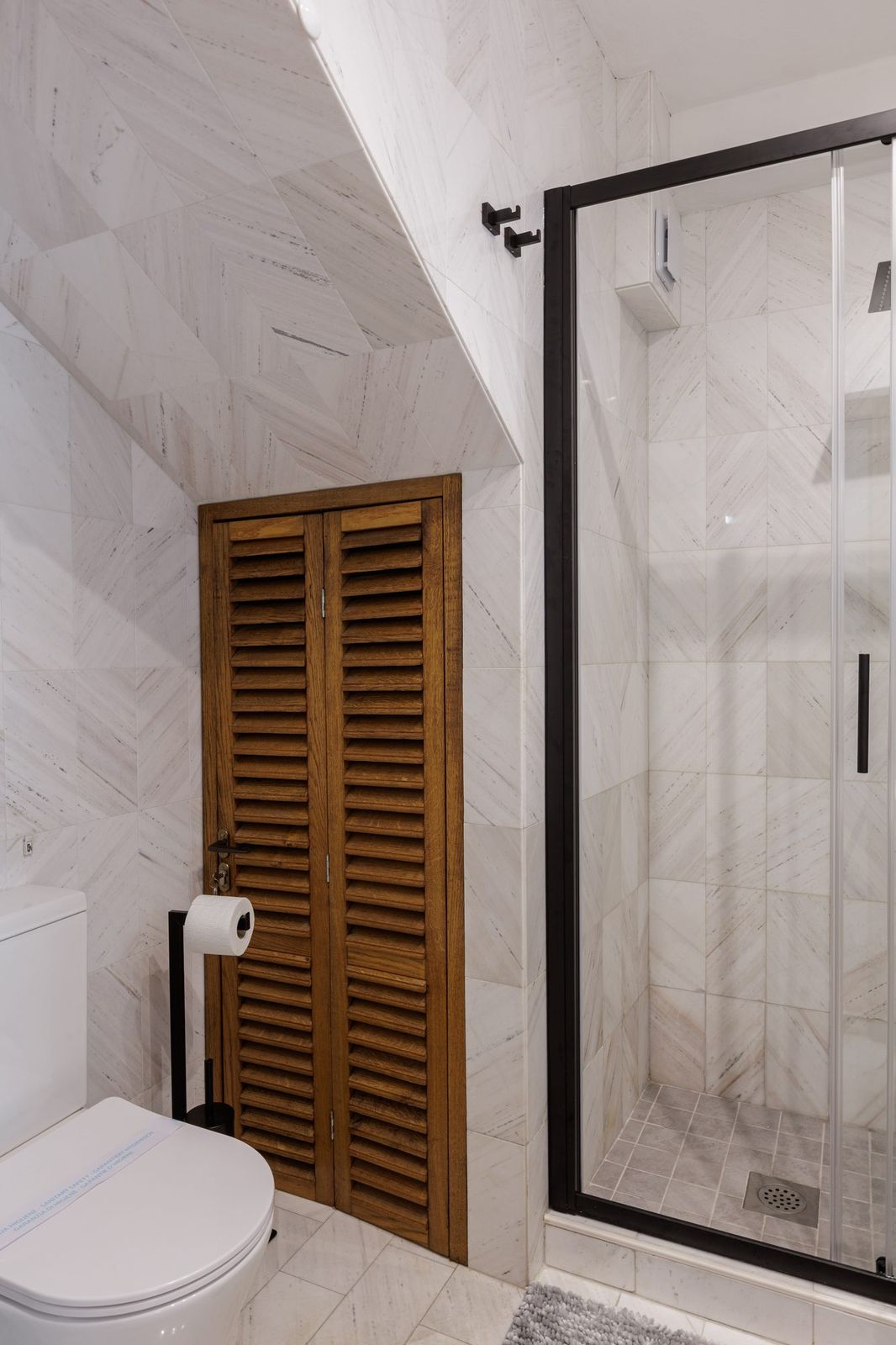 Modern bathroom, louvred wooden doors and glass shower enclosure
