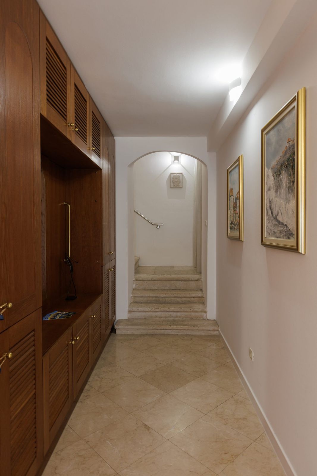 The entrance hall with built-in wooden wardrobes and stairs to the upper floor